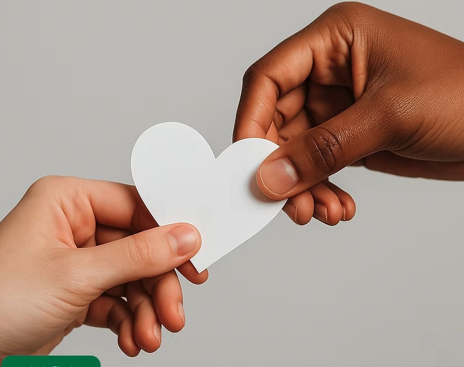 Hands passing a white heart to represent donation impact